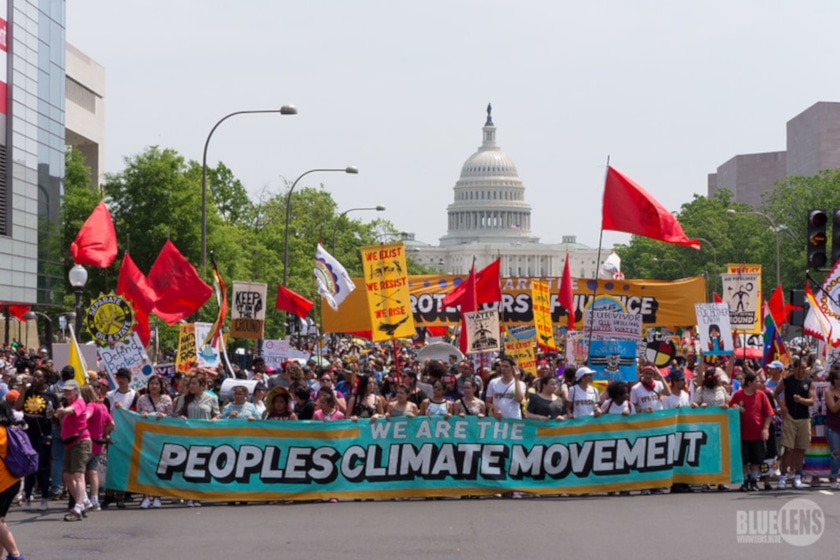 A bunch of people marching in Washington, DC with a poster that says “We are the people's climate movement”.
